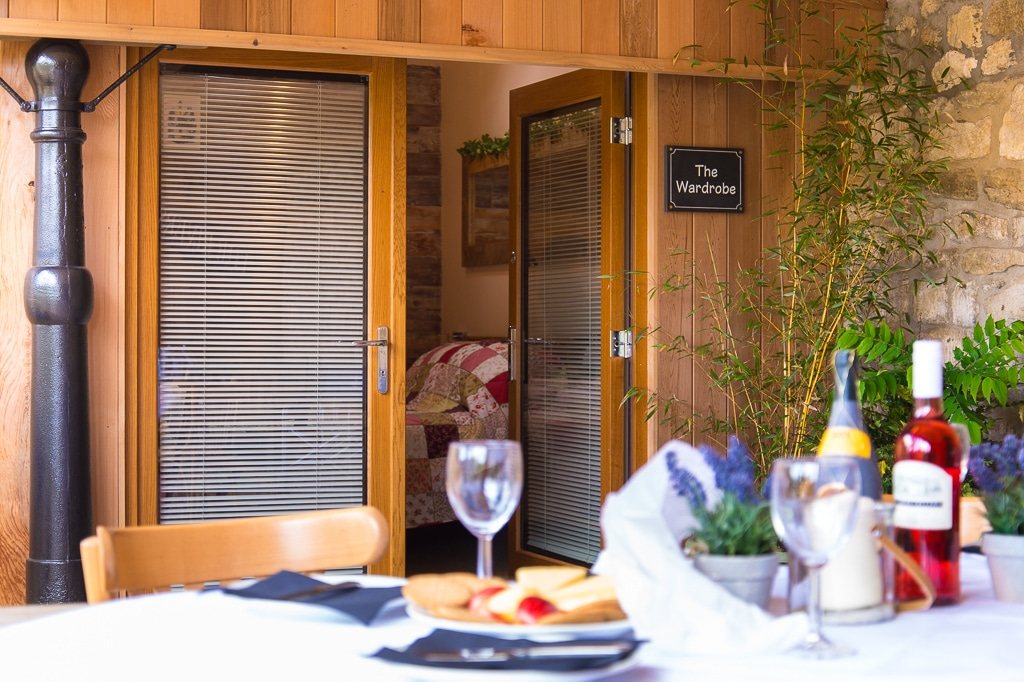 A table set for two outside one of the barn rooms